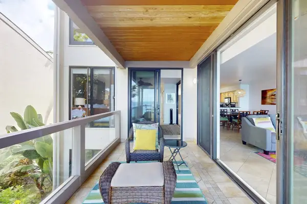 Covered Private Balcony with Outdoor Lounge Chair, Coffee Table, and Sliding Glass Door Access