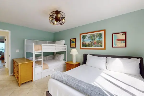 Guest Bedroom Featuring Queen Bed, Bunk Bed Setup, Wooden Dresser, and Framed Wall Art