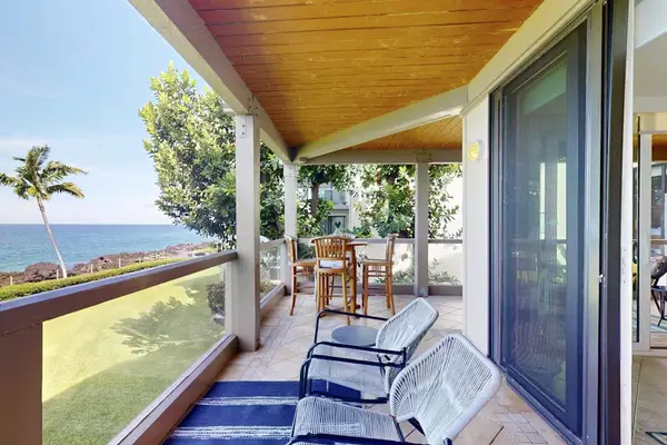 Covered Oceanfront Balcony with Outdoor Lounge Chairs, Dining Table, and Ocean Views