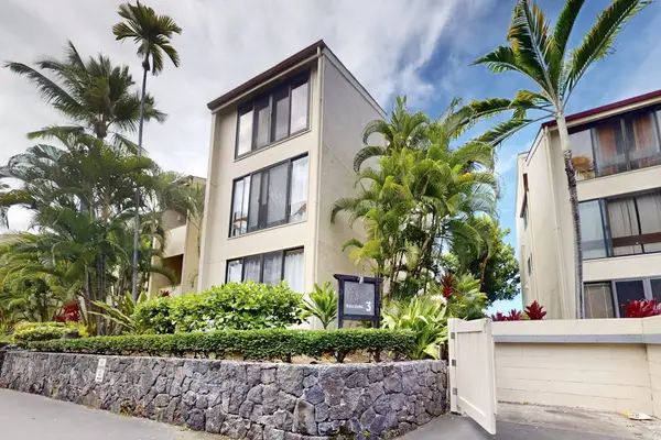 Modern Multi-Story Resort Building Exterior Framed by Tropical Palm Trees and Landscaping