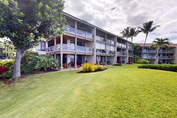 Resort Exterior View Featuring Manicured Green Lawn, Private Balconies, and Tropical Trees