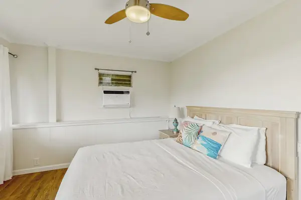 Relax in a welcoming bedroom with a queen bed and gentle overhead breeze.