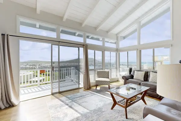 Relax in the living room beside the expansive glass wall, bringing in beautiful natural light.