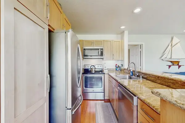 Modern kitchen showcases sleek cabinets, useful appliances, and generous counters