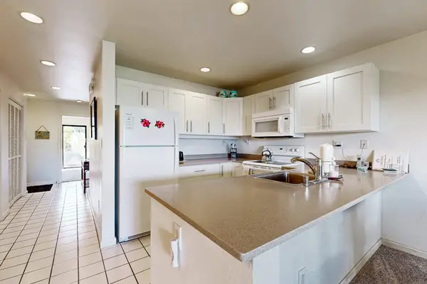 Kitchen island anchors bright cabinetry appliances and practical preparation space