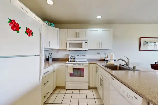 Galley kitchen counters support easy cooking beneath cheerful overhead lighting
