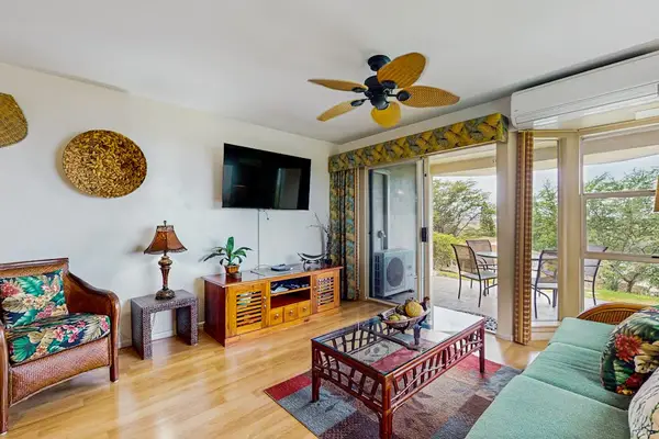 Bright living room with comfortable seating and TV.