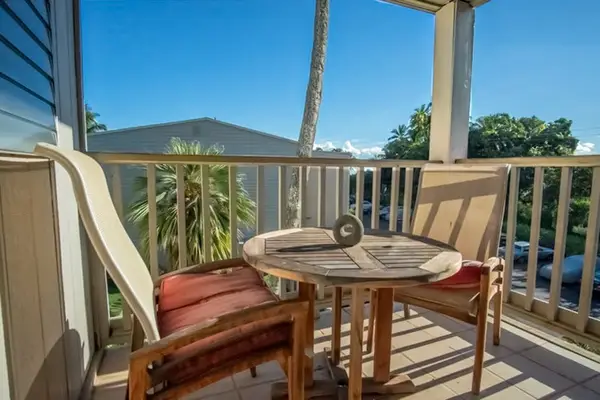 Balcony dining area offers table seating and tropical views outside