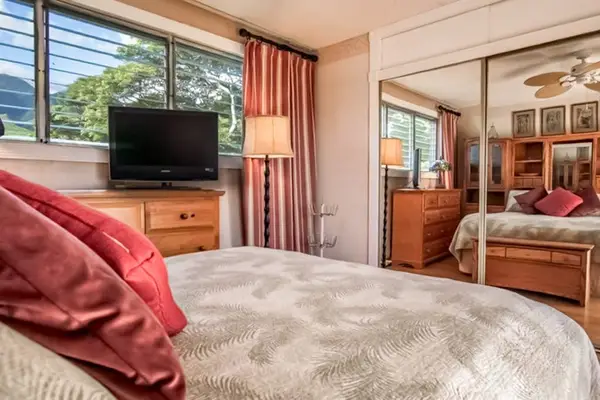 Bright bedroom features scenic window views and a large mirror for added convenience