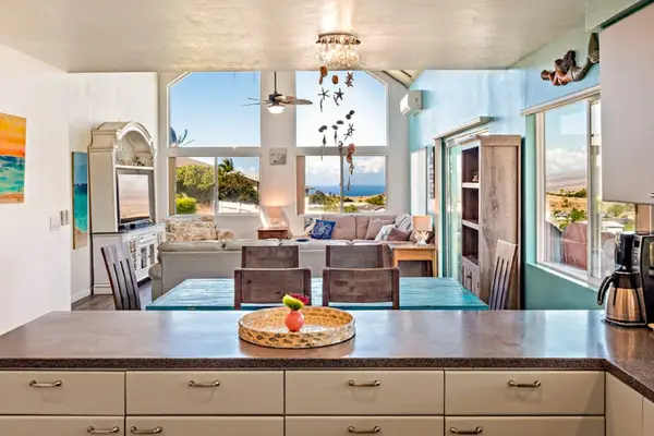 Large open update kitchen with stainless steel appliances with a view to the living room and light from the floor to ceiling windows.