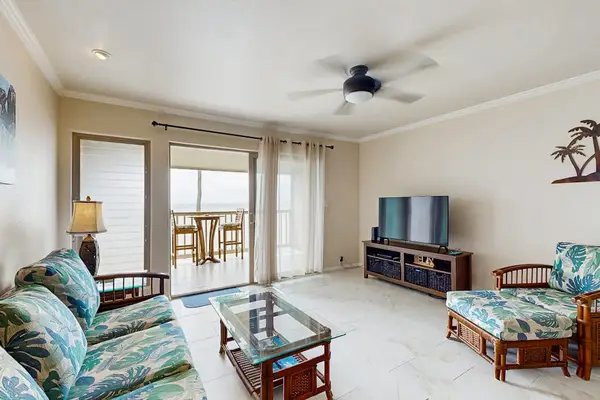 Airy living room features twin armchairs coffee table and television
