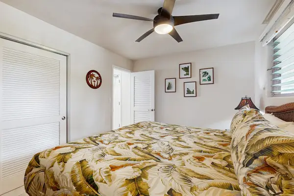 First bedroom offers king bed floral quilt tables and sunlight