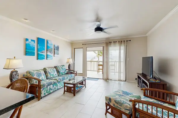 Living room offers ceiling fan seating and expansive balcony views