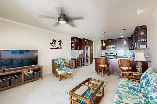 Kitchen includes dark cabinetry modern appliances and granite counters backsplash