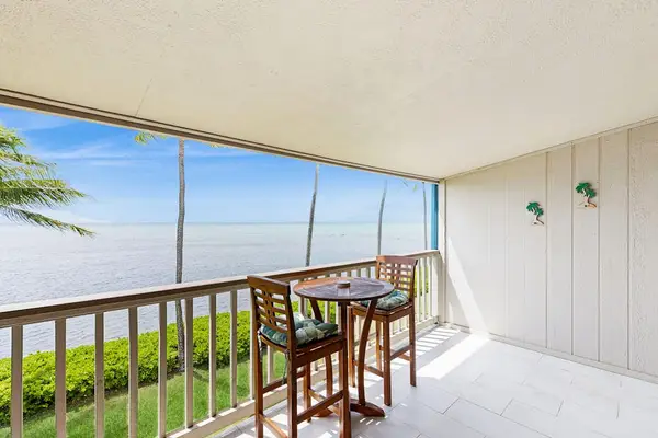 Covered balcony offers outdoor dining with breezy tropical ocean views