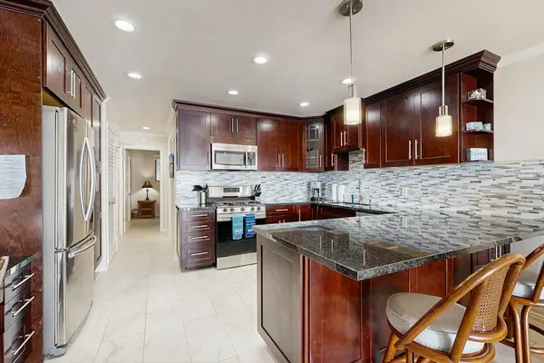 Kitchen dining space shares warm cabinetry and bright natural light