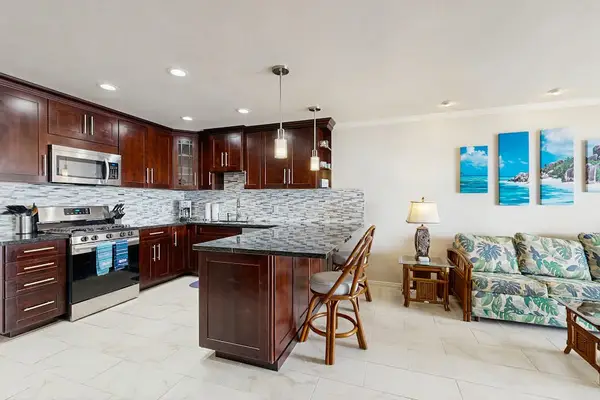Kitchen island anchors dining space with dark cabinetry and decor