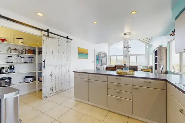Large open update kitchen with stainless steel appliances.