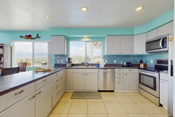 Large open update kitchen with stainless steel appliances.