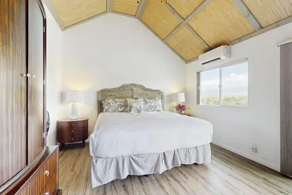 Master bedroom with king bed and vaulted ceilings.