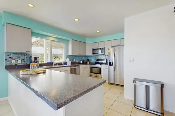Large open update kitchen with stainless steel appliances.