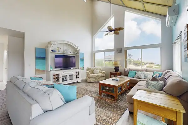 Living room with lots of plush seating, flat screen tv and views from the floor to ceiling windows.