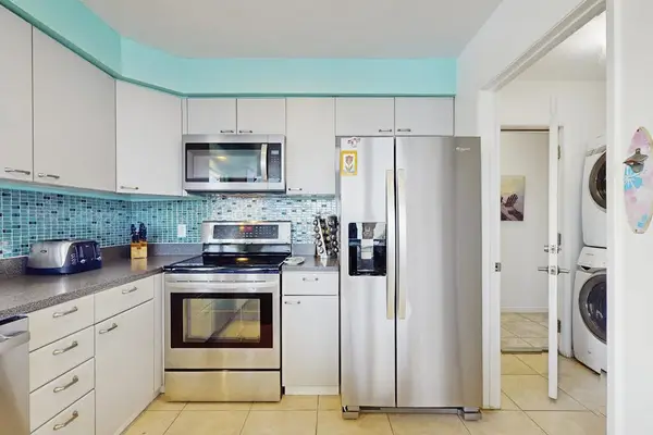 Large open update kitchen with stainless steel appliances.