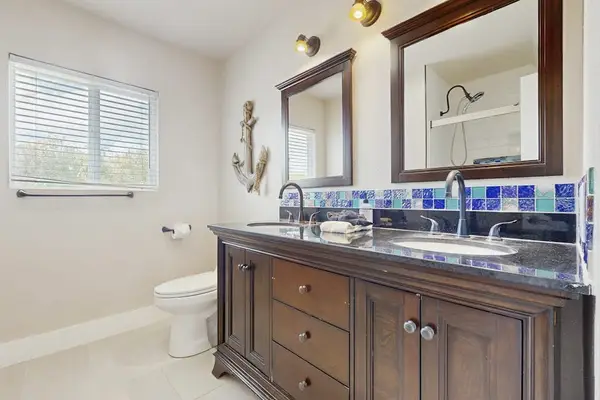 Guest bathroom with double sinks and a walk-in shower.
