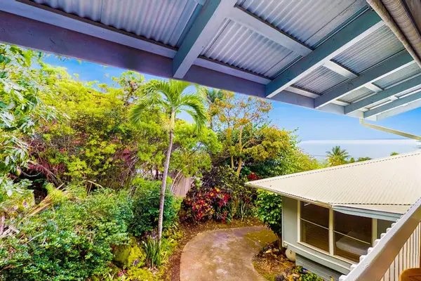 Tropical landscaping surrounds the studio with open sky and greenery
