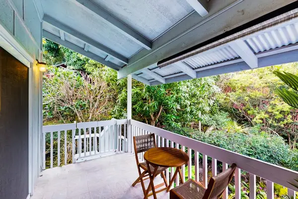 Covered seating overlooks tropical gardens and a coastal horizon