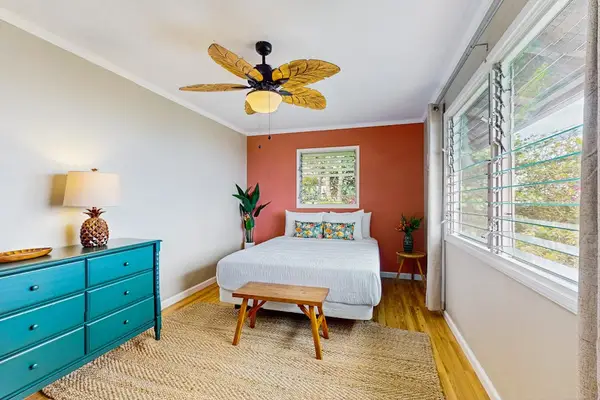 Bedroom offers queen bed dresser ceiling fan and garden views
