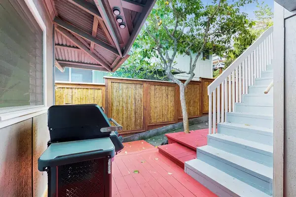 Outdoor BBQ area provides grill space beside steps and greenery