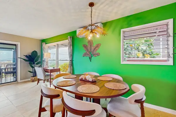 Dining area offers comfortable seating beside bright windows and kitchen