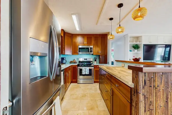 Kitchen features stainless appliances island seating and ample preparation space