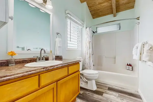 Full bathroom features vanity shower mirror and clean tiled finishes