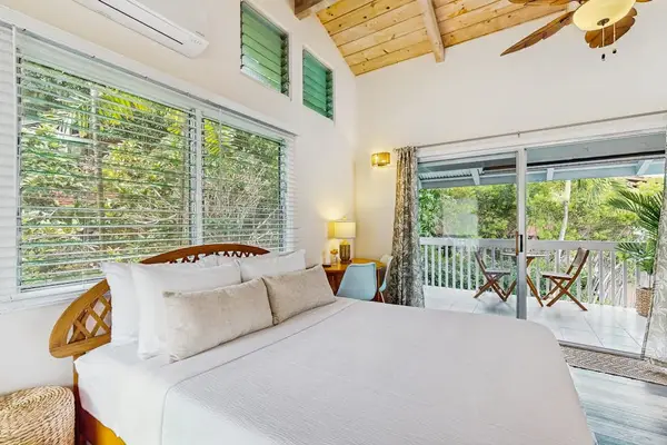 ​Cozy queen bedroom with wood-paneled high ceiling