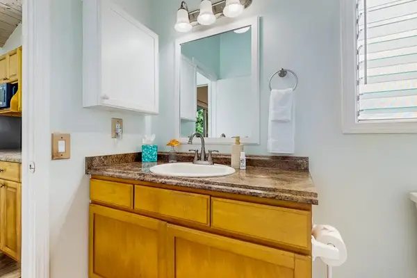 Bathroom vanity area offers mirror storage and bright clean finishes