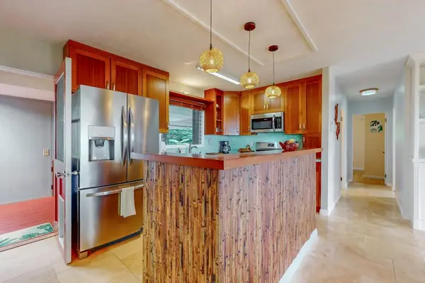 Kitchen island anchors bright cooking space with stainless appliances nearby