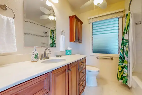 Full bathroom features double vanity mirror shower and tropical window