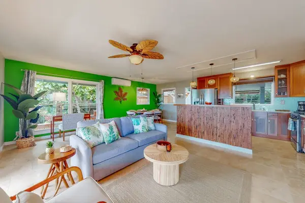 Open living area combines colorful furnishings kitchen and island light