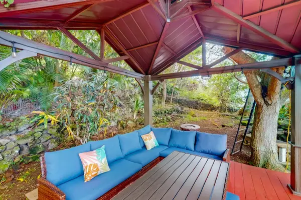 Covered gazebo lounge offers colorful seating for relaxed garden gatherings