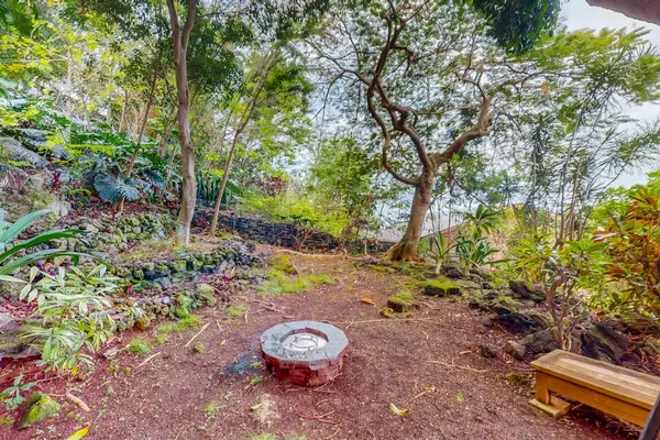 Wooded courtyard features firepit seating and peaceful garden surroundings nearby