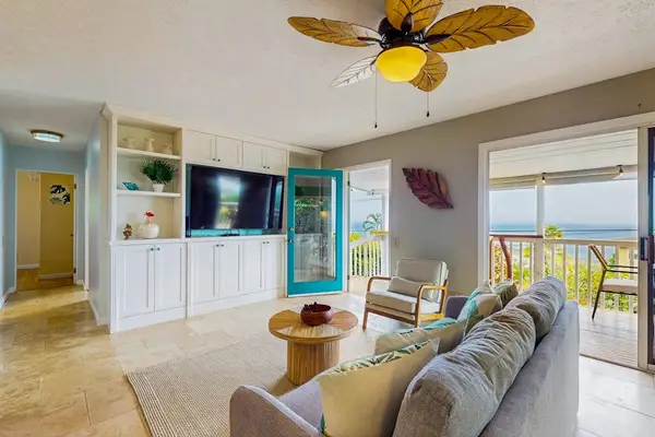 Open living room featBright living room showcases colorful decor seating and natural lightures television sofa seating and balcony access