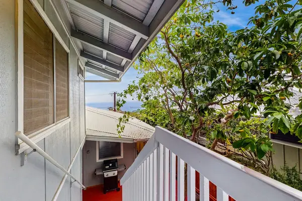 Balcony overlooks tropical gardens and neighboring island scenery below