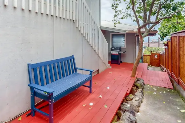 Pavilion provides shaded seating among tropical plants and stone walls