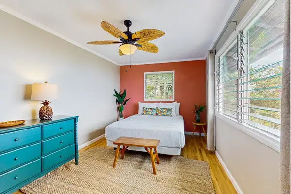 First bedroom includes daybed dresser ceiling fan and garden windows