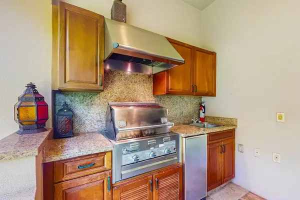 Dine at the nearby table for six, or push back the sliding glass doors and unite the indoors with the outdoors with an additional table and chairs and a wet bar with a gas grill, heating drawers, and a minifridge.
