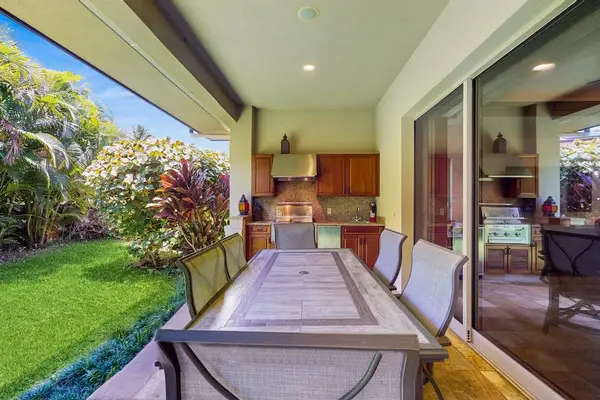 Dine at the nearby table for six, or push back the sliding glass doors and unite the indoors with the outdoors with an additional table and chairs and a wet bar with a gas grill, heating drawers, and a minifridge.
