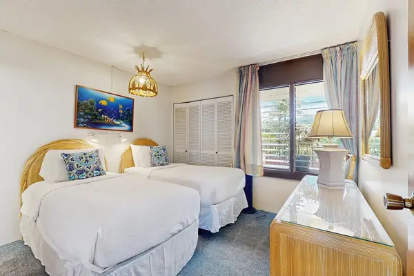 The bright guest bedroom provides a comfortable retreat with tropical charm.