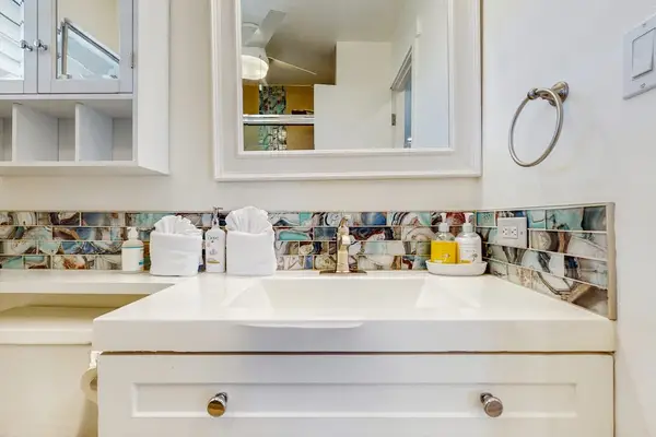 The bright bathroom vanity provides generous counter space for your daily routine.